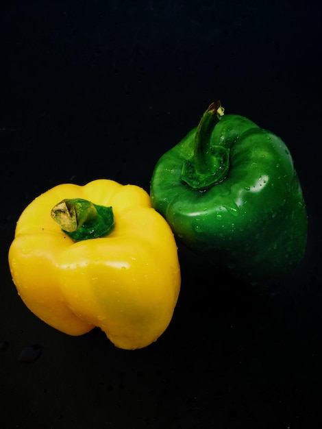 Photo vue rapprochée du poivre jaune sur table sur un fond noir