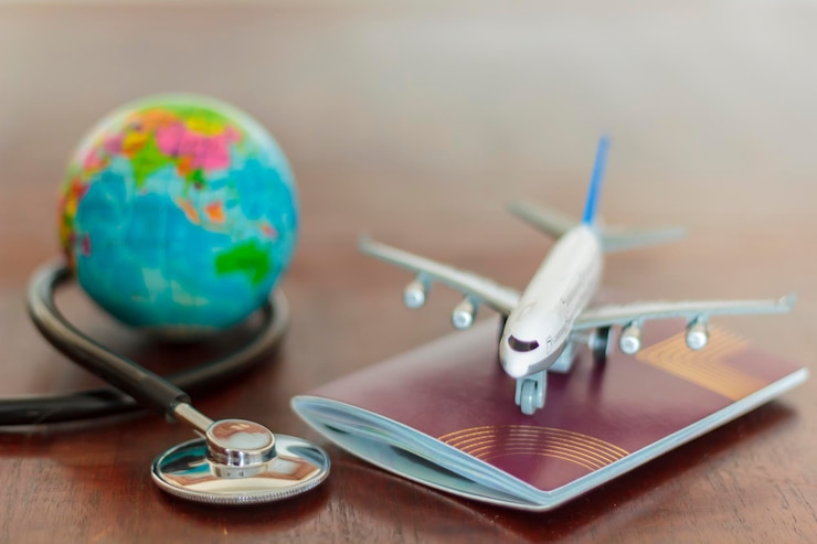 Photo vue rapprochée du stéthoscope avec un modèle d'avion et un passeport sur la table
