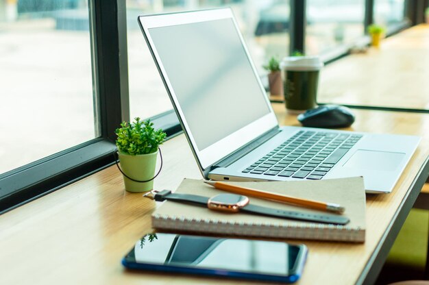 Vue rapprochée du téléphone portable et de l'ordinateur portable sur la table à côté de la fenêtre