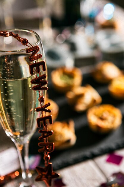 Photo vue rapprochée du texte du nouvel an sur la flûte au champagne à table