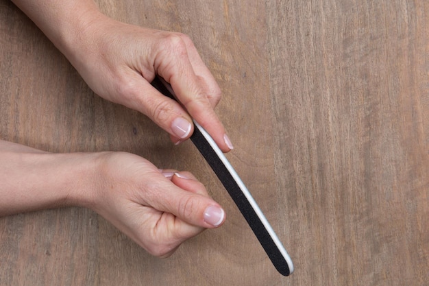 Vue rapprochée du traitement des ongles sur fond de bois