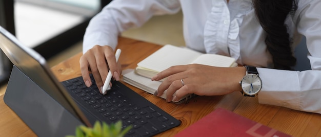 Vue rapprochée de l'employé de bureau travaillant avec tablette numérique et papeterie sur table en bois