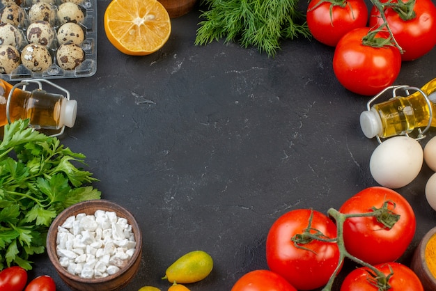 Vue rapprochée de l'espace vide parmi les légumes frais tombés bouteille d'huile oeufs de citron paquets verts sur fond noir