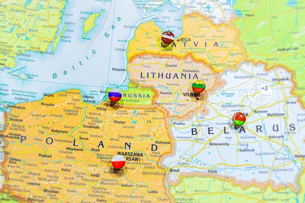 Photo vue rapprochée des états baltes sur un globe géographique, la carte montre les capitales des pays lettonie - riga, lituanie - vilnus, estonie - tallin pologne - cracovie et région de kaliningrad en russie et leurs drapeaux.