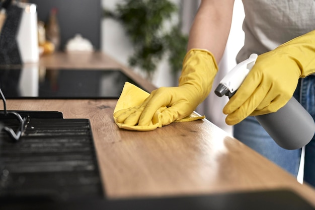 Vue rapprochée d'une femme caucasienne nettoyant la cuisine à la maison