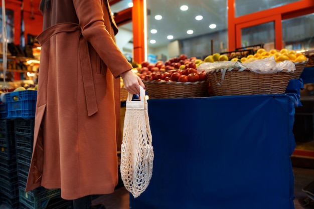 Vue rapprochée d'une femme choisissant des fruits et légumes au marché des agriculteurs