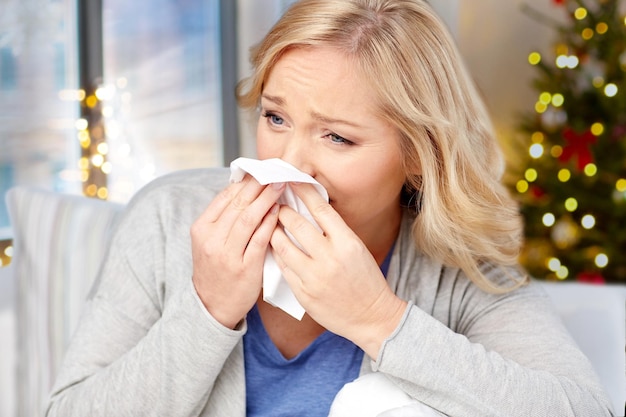 Photo vue rapprochée d'une femme malade qui souffle le nez à noël