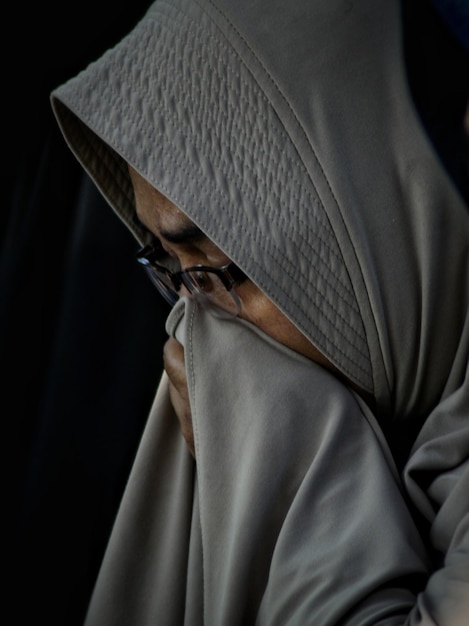 Photo vue rapprochée d'une femme mature en hijab sur un fond noir