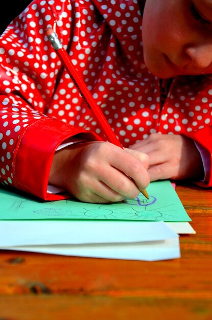 Photo vue rapprochée d'une fille dessinant sur papier