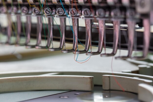 Vue rapprochée de fils colorés dans une machine à coudre