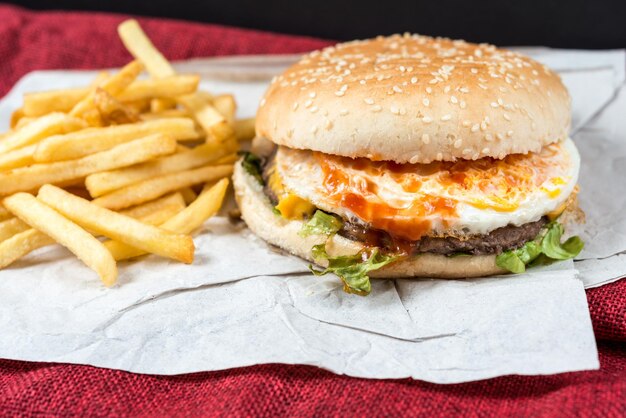 Photo vue rapprochée des frites et du hamburger sur la nappe