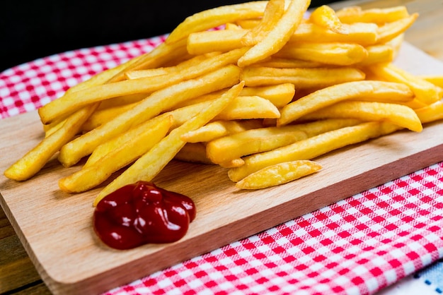 Vue rapprochée de frites avec ketchup sur table sur fond noir