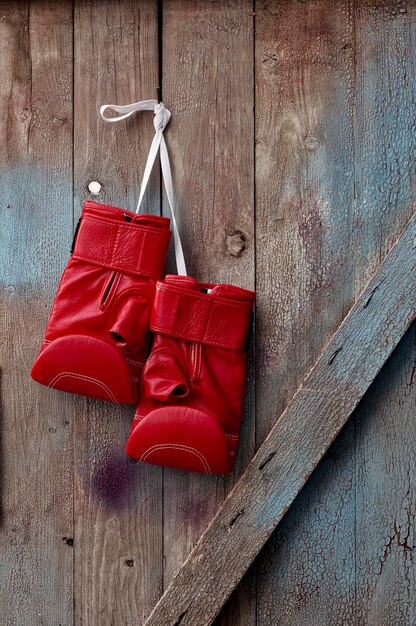 Photo vue rapprochée de gants de boxe rouges accrochés au bois