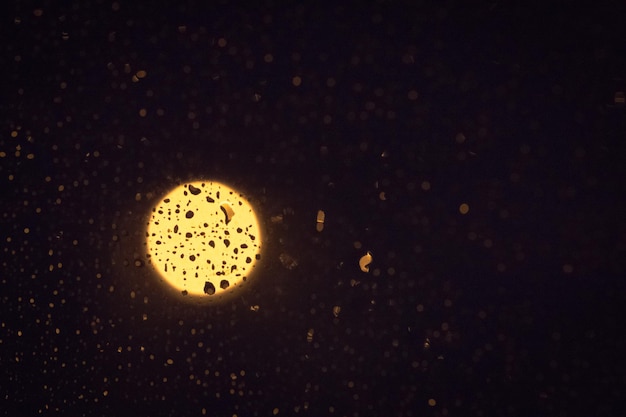 Photo vue rapprochée des gouttes d'eau sur le verre contre la lune