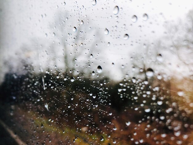 Photo vue rapprochée des gouttes de pluie sur une fenêtre en verre