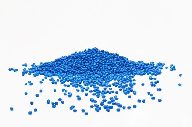 Vue rapprochée des granulés de polymère bleus sur fond blanc