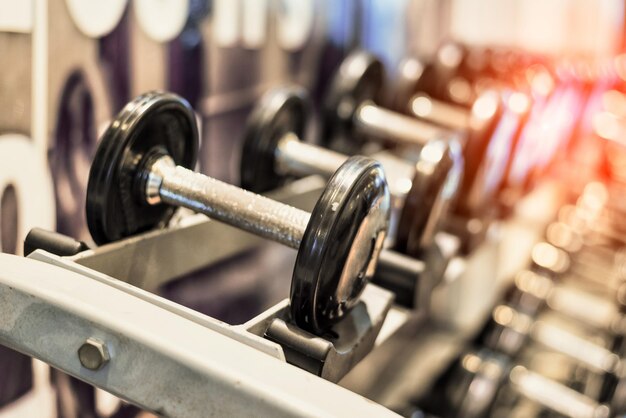 Photo vue rapprochée des haltères sur le rack au gymnase