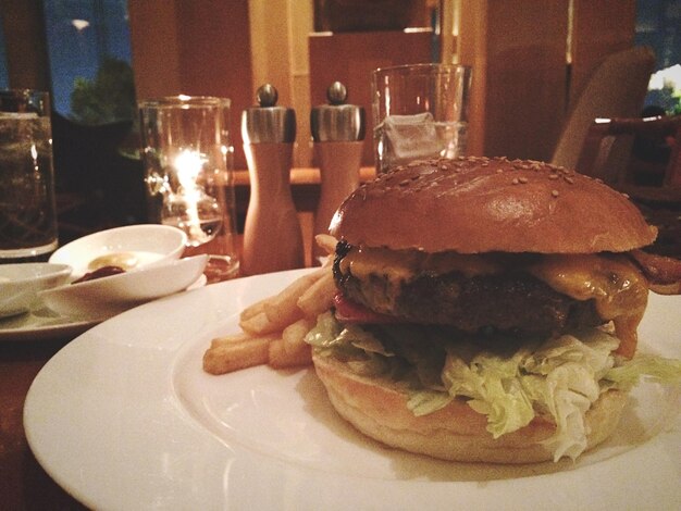 Photo vue rapprochée d'un hamburger servi dans une assiette sur la table d'un restaurant