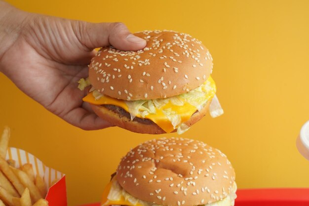 Vue rapprochée d'un hamburger tenu à la main