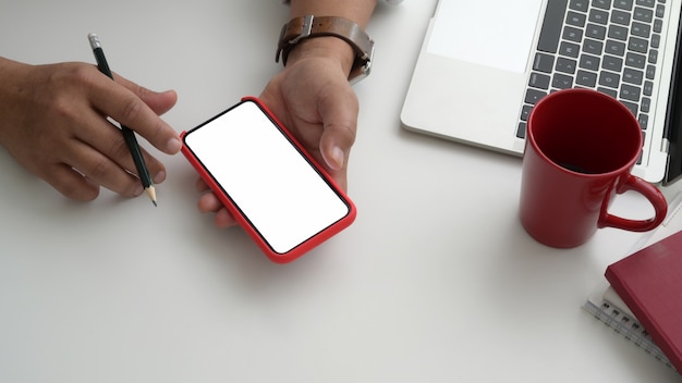 Vue rapprochée d'homme d'affaires à l'aide de téléphone dans sa salle de bureau moderne