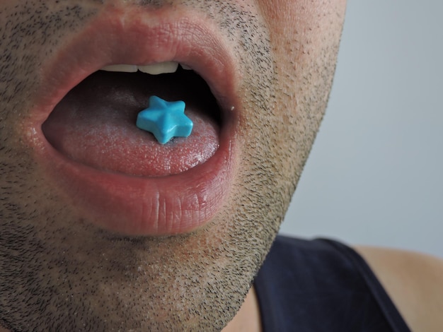 Photo vue rapprochée d'un homme mangeant des bonbons bleus