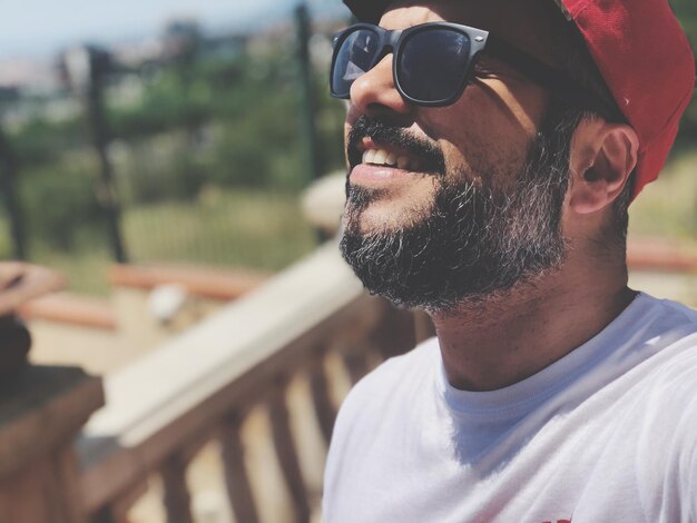 Photo vue rapprochée d'un homme souriant portant des lunettes de soleil