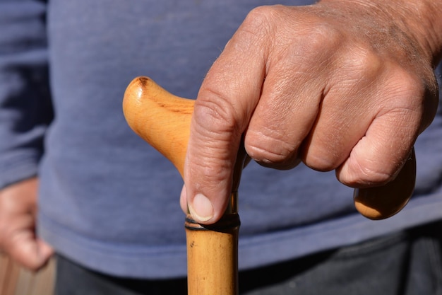 Vue rapprochée d'un homme tenant une canne à marcher