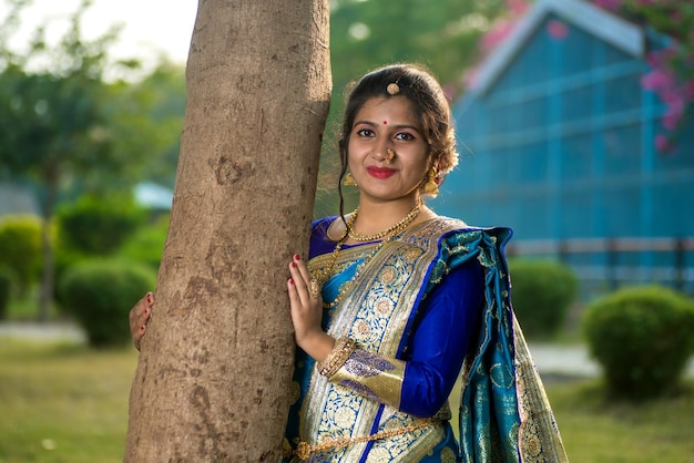 Vue rapprochée de l'indie traditionnelle belle jeune fille en saree posant à l'extérieur du parc