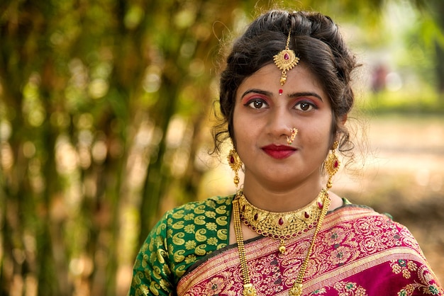 Vue rapprochée de l'indie traditionnelle belle jeune fille en saree posant à l'extérieur du parc