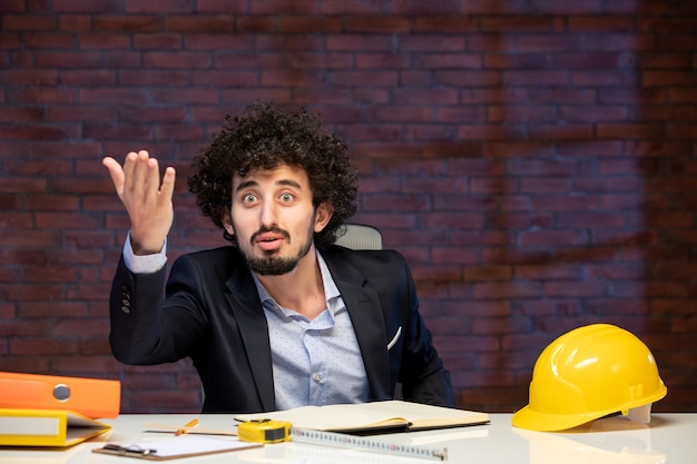 Photo vue rapprochée de l'ingénieur masculin assis derrière son lieu de travail en fonction de l'ordre du jour de l'emploi de l'entrepreneur d'architecture d'affaires plan de constructeur de travail d'entreprise