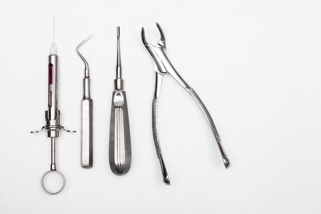 Vue rapprochée des instruments dentaires sur fond blanc