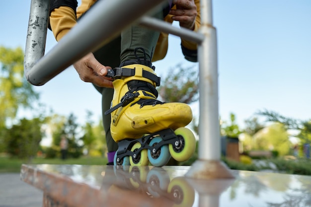 Vue rapprochée sur la jambe masculine portant des patins à roulettes. Verrou de protection à encliquetage manuel sur les bottes pour une conduite en toute sécurité