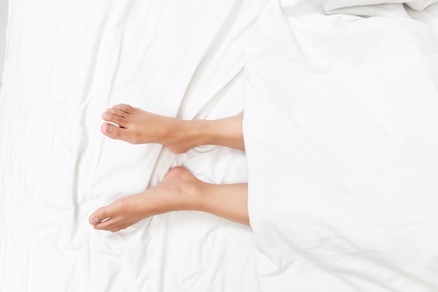 Vue rapprochée des jambes d'une femme sur un lit