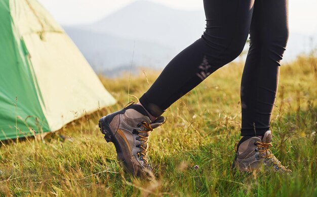 Vue rapprochée des jambes de la femme près de la tente Majestueuses montagnes des Carpates Beau paysage de nature intacte