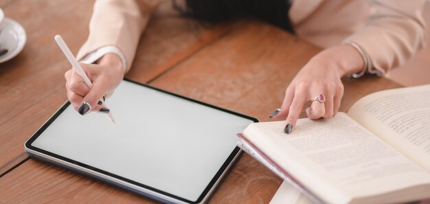 Vue rapprochée de la jeune femme d'affaires travaillant sur son projet avec tablette numérique à écran blanc