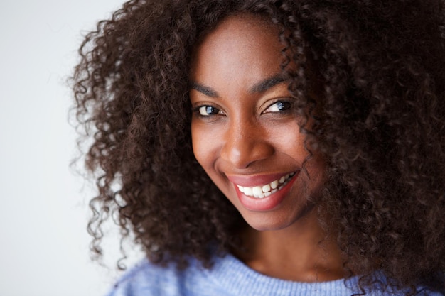 Vue rapprochée d'une jeune femme afro-américaine souriante sur un fond blanc