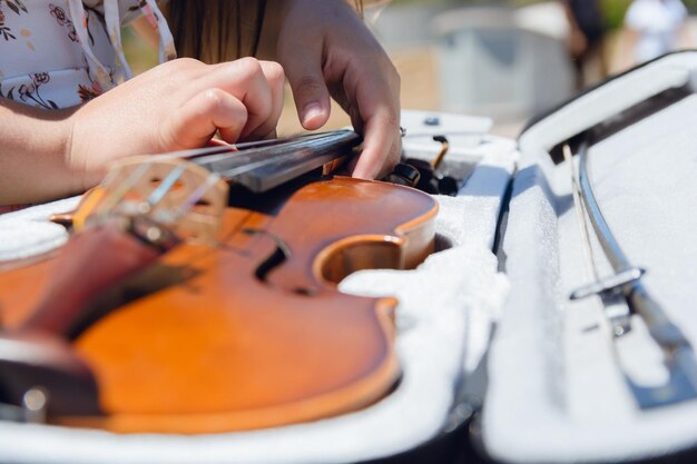 Vue rapprochée d'une jeune femme inconnaissable qui joue du violon dans la rue au cas où