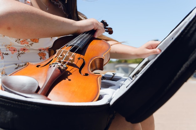 Vue rapprochée d'une jeune femme inconnaissable qui joue du violon dans la rue au cas où