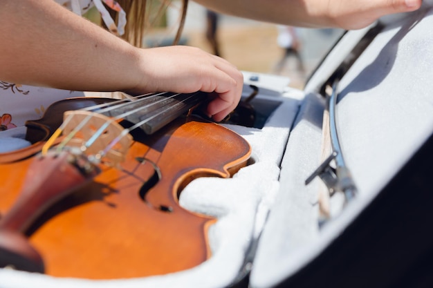 Vue rapprochée d'une jeune femme inconnaissable qui joue du violon dans la rue au cas où