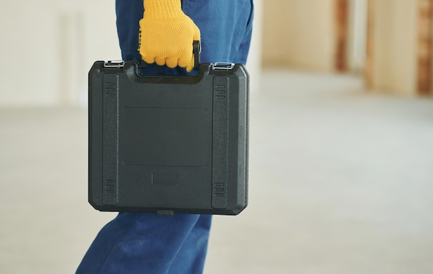 Vue rapprochée Jeune homme travaillant en uniforme à la construction pendant la journée