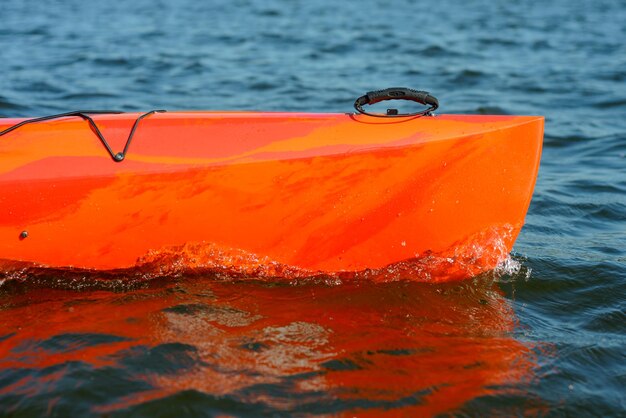 Vue rapprochée d'un kayak rouge sur une belle rivière ou un lac le soir
