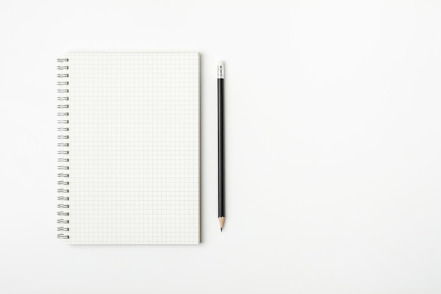 Vue rapprochée d'un livre ouvert avec un crayon sur fond blanc