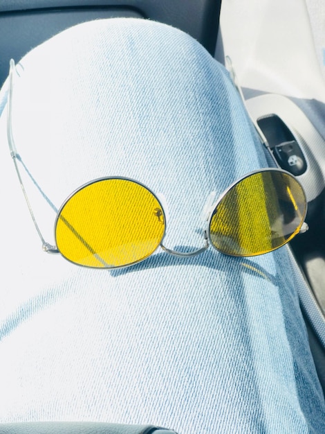 Photo vue rapprochée des lunettes de soleil jaunes sur la jambe