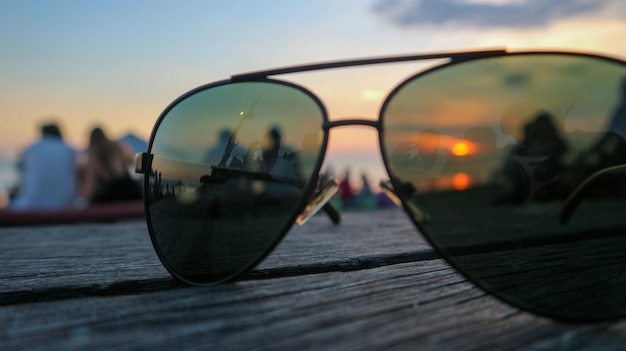 Vue rapprochée des lunettes de soleil sur la table contre le ciel au coucher du soleil