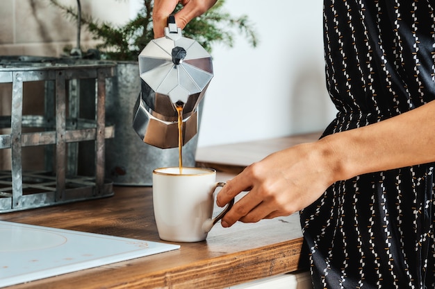 Vue rapprochée de la main féminine verser le café