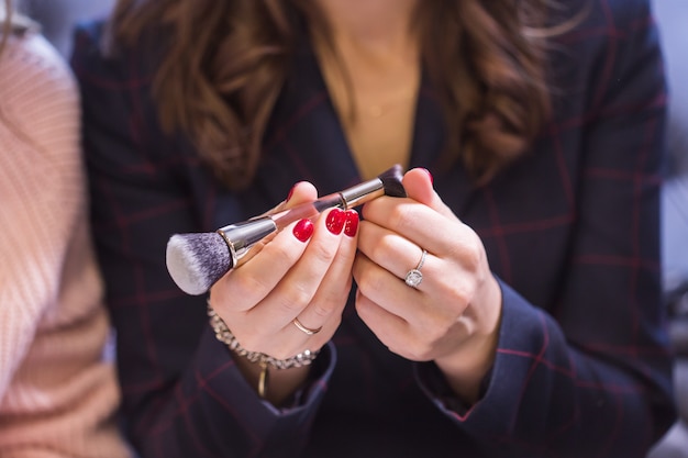 Vue rapprochée de la main de femme tenant le pinceau de maquillage