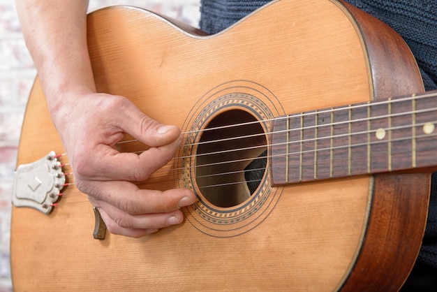 Vue rapprochée de la main de l'homme jouant de la guitare