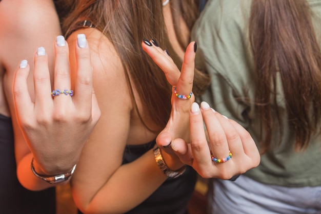 Vue rapprochée d'une main d'homme montrant une bague avec un bracelet arc-en-ciel lgbt