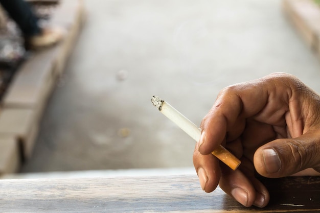 Vue rapprochée d'une main humaine tenant une cigarette