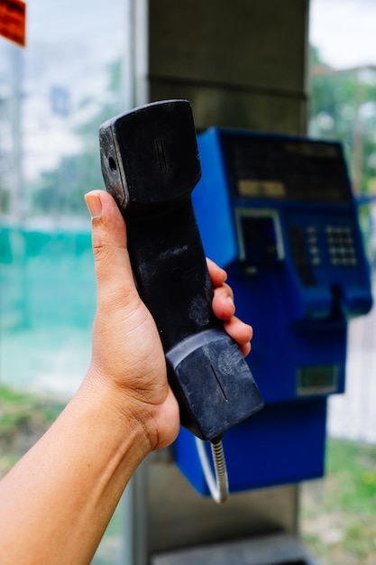 Photo vue rapprochée d'une main humaine tenant un récepteur téléphonique